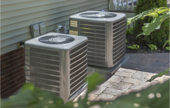Two AC condensers outside a house.